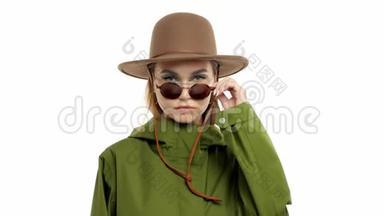 在<strong>绿皮</strong>大衣和帽子的工作室里，一个秋天看的女人转身向镜头摆姿势